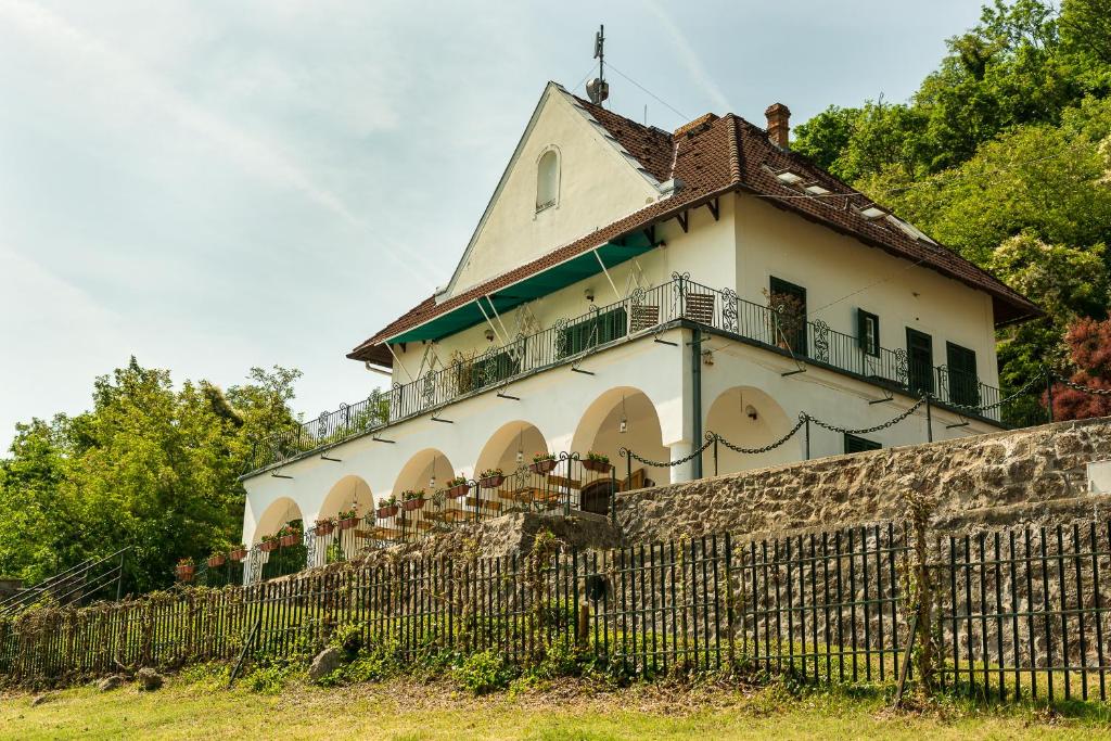 a building with a balcony on top of a wall at Villa Kabala in Szigliget