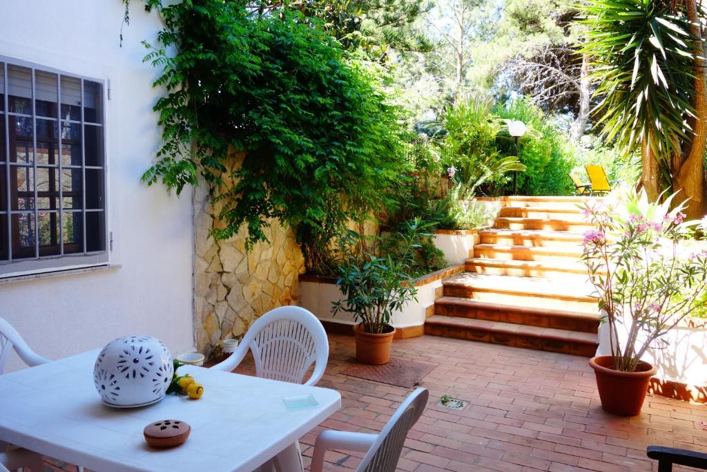 eine Terrasse mit einem Tisch, Stühlen und Treppen in der Unterkunft Villa Maria in Mondello