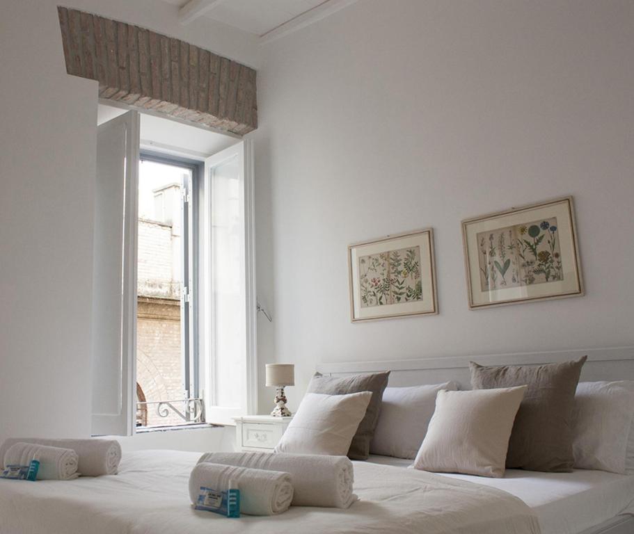 biała sypialnia z dużym łóżkiem i ręcznikami na nim w obiekcie Splendid House In Trastevere w Rzymie