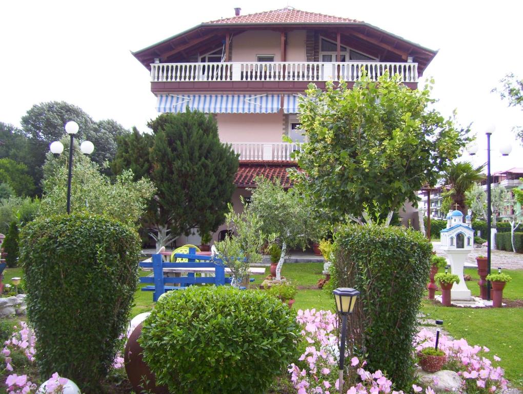 a building with a garden with bushes and flowers at Verginia Studios in Korinos