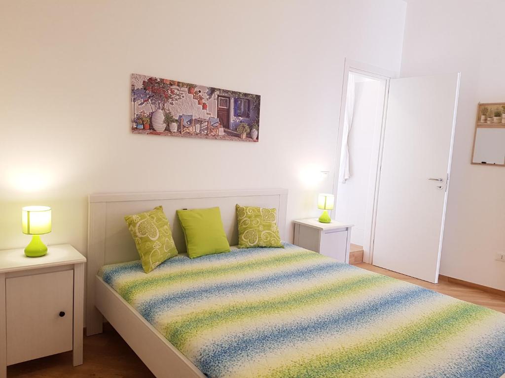 una camera da letto con un letto con cuscini verdi di B&B Verdearancio a Monopoli