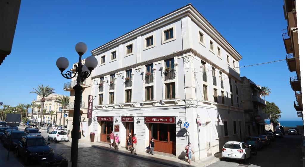 un edificio blanco en la esquina de una calle en Hotel Villa Ada, en Pozzallo