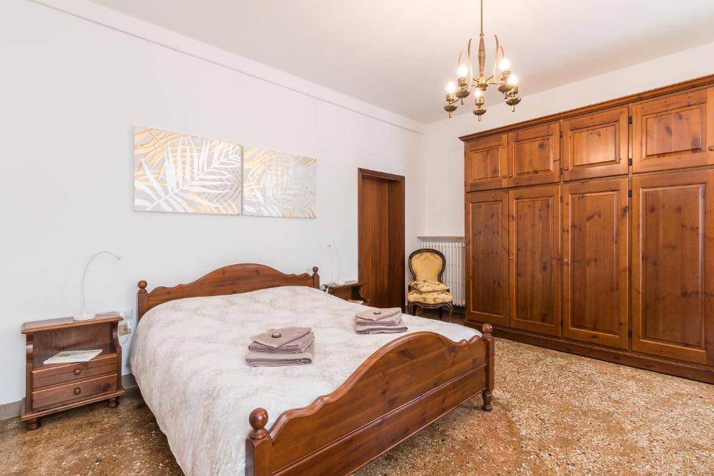 a bedroom with a bed and a wooden cabinet at Ca' Dada Appartamento in Venice