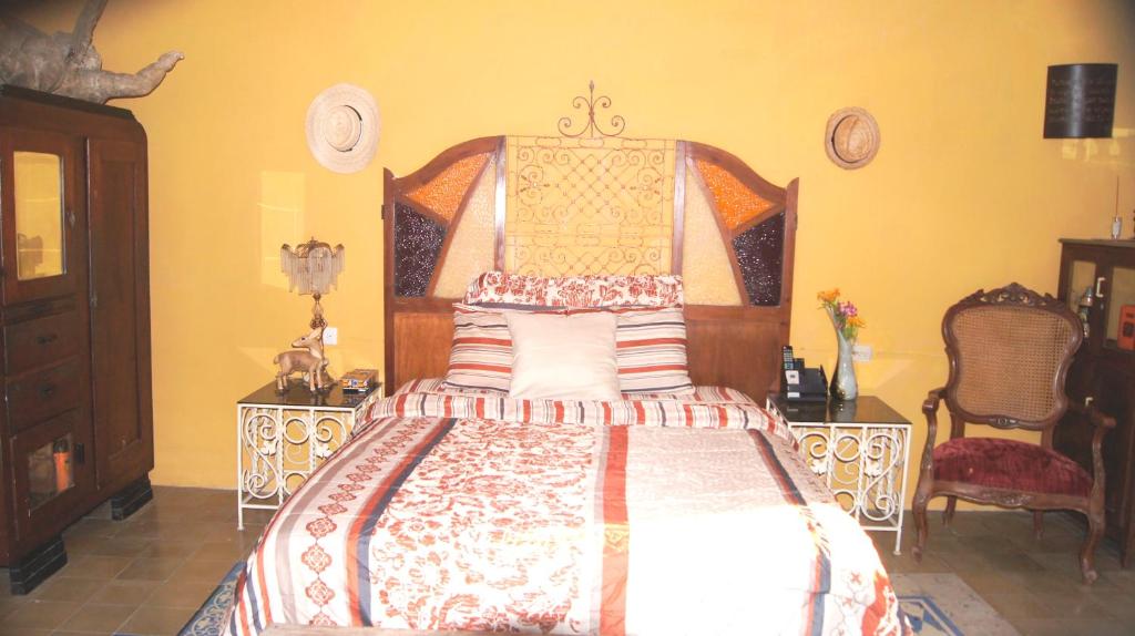 a bedroom with a bed with a wooden head board at Casa De Piedra, Centro Histórico in Mérida
