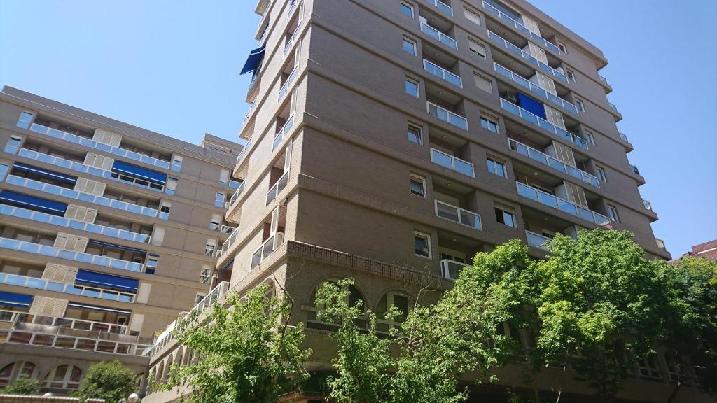 wysoki budynek apartamentowy z drzewami przed nim w obiekcie Fabiola Zentro w Saragossie
