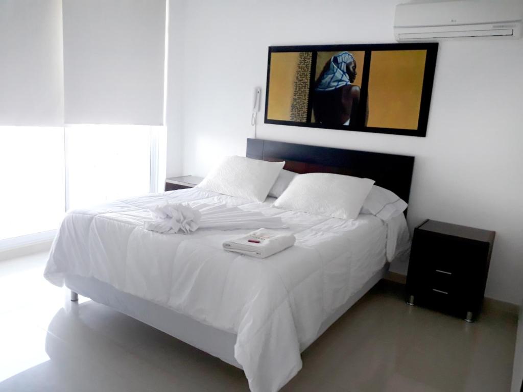 Una cama blanca con una bandeja encima. en Hotel Sophia Real, en Yopal
