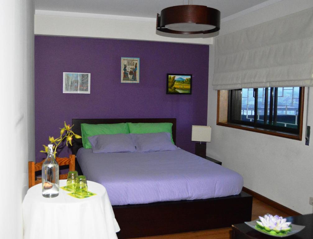 um quarto roxo com uma cama e uma mesa em Matosinho's Palace em Matosinhos