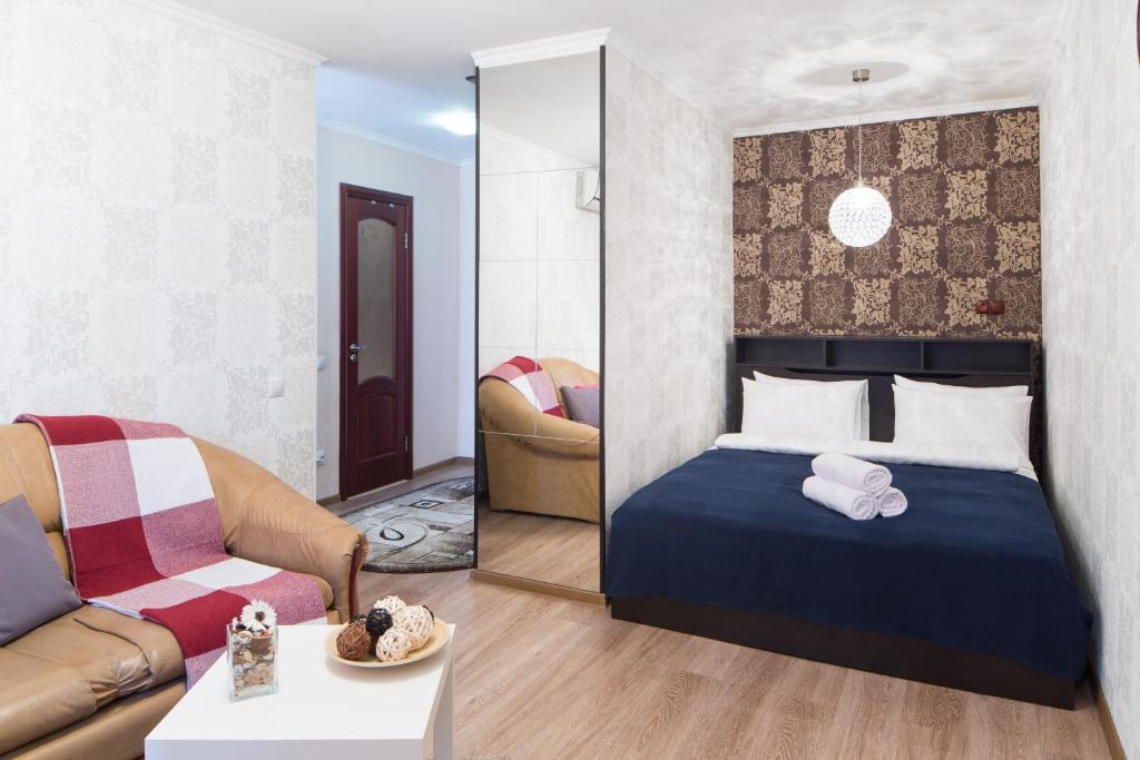 モスクワにあるLux Apartment Uralskayaのベッドルーム1室(ベッド1台付)、リビングルームが備わります。
