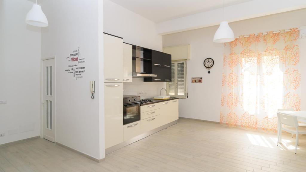 a kitchen with white cabinets and a table and a window at Lazzarella Loft in Naples