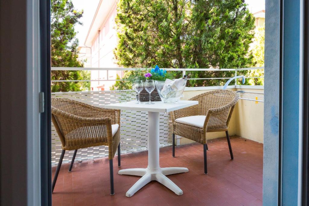 a white table and chairs on a balcony at Hotel Maxim in Caorle