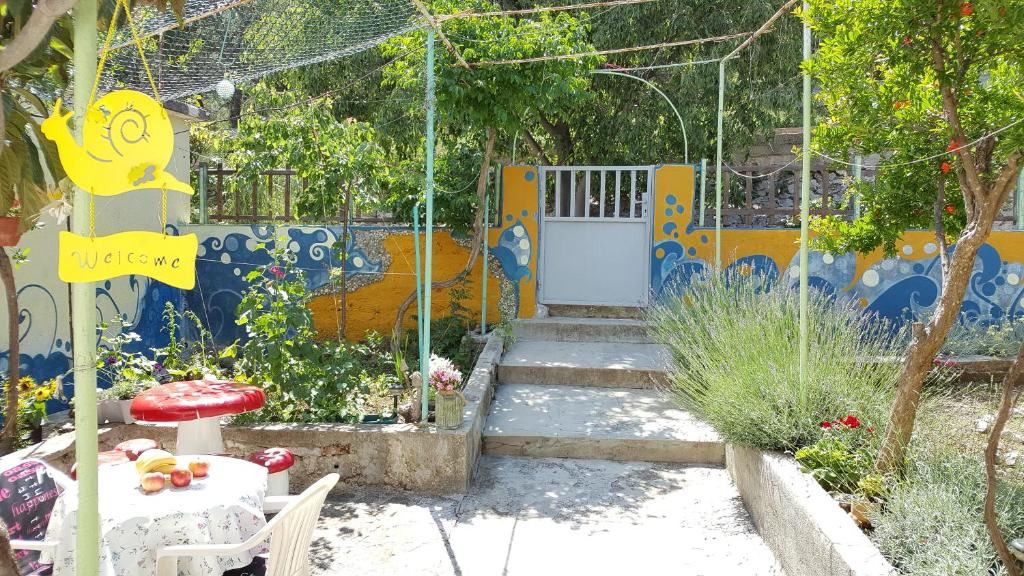 a garden with a blue and yellow wall with a door at Barone 4 You in Šibenik