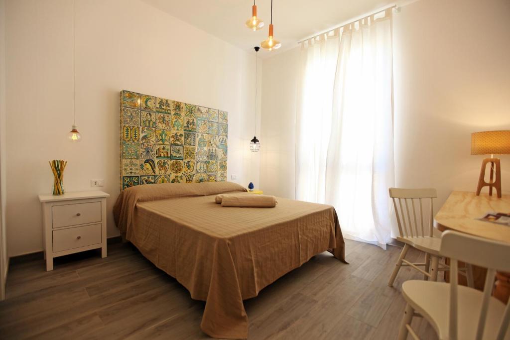 a bedroom with a bed and a table and a window at Via Siracusa 5 in Castellammare del Golfo