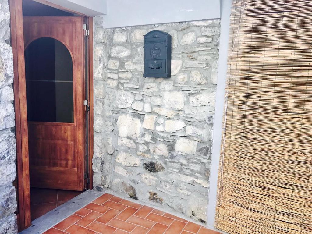 een stenen muur met een houten deur en een brievenbus bij Appartamento Armonia in Podenzana