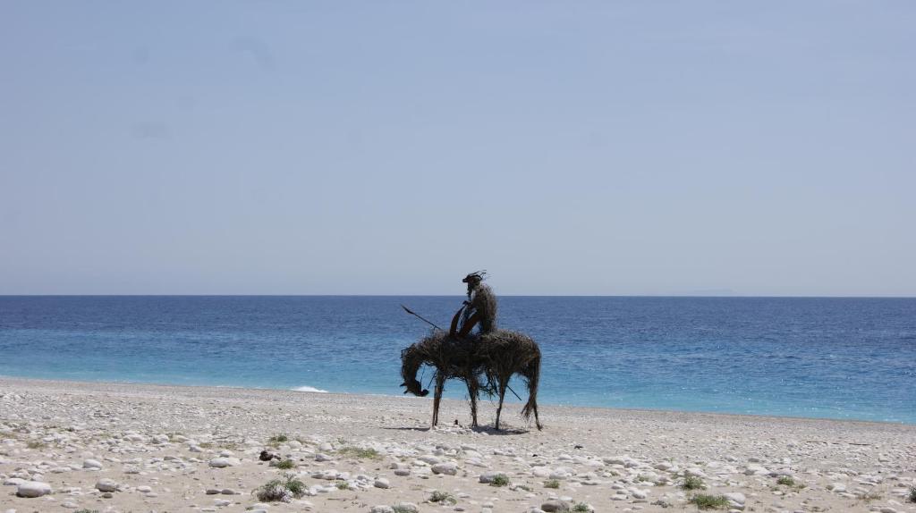 a person riding a horse on the beach at Augustus Hotel in Dhërmi