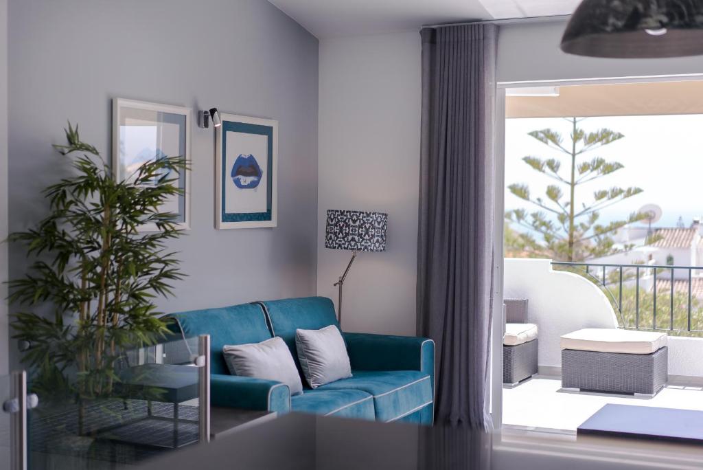 sala de estar con sofá azul y balcón en ATLANTIC VIEW Apartment, en Luz