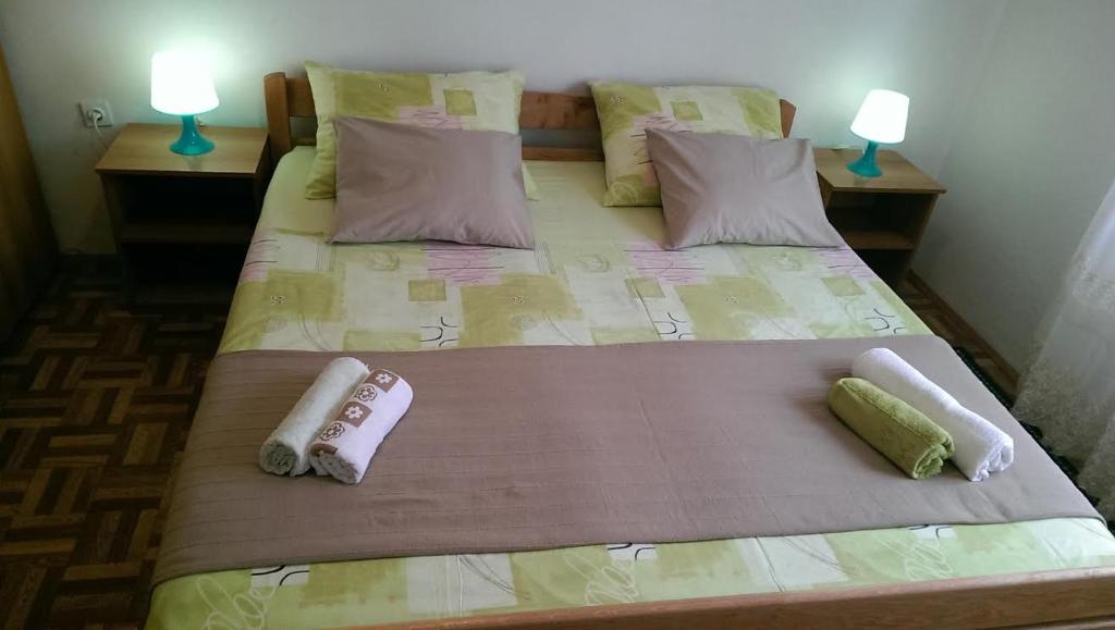 a bedroom with two beds with pillows and two lamps at Apartmani Ledenko in Kaštela