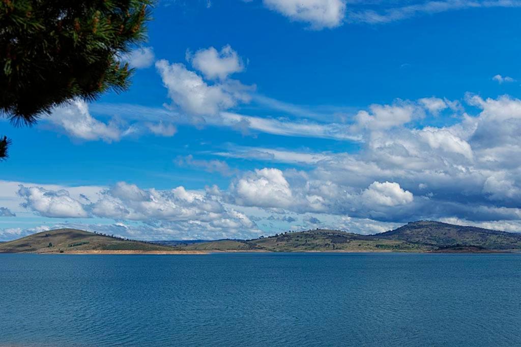 a large body of water with mountains in the background at Rainbow Pines Tourist Caravan Park in Adaminaby