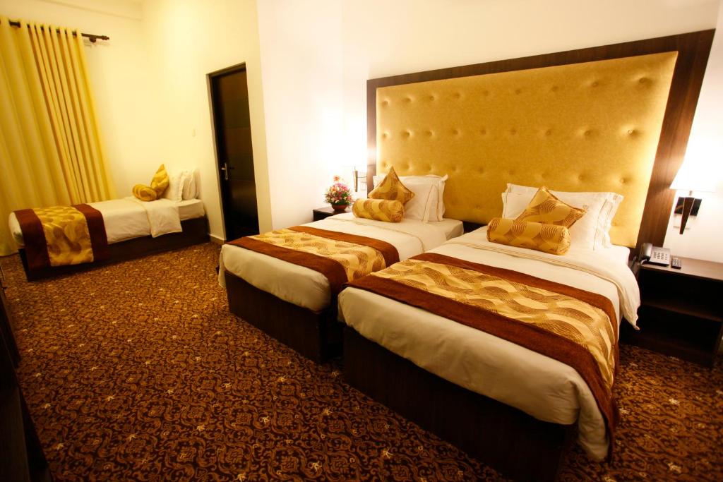 Postel nebo postele na pokoji v ubytování The Queensburry City Hotel