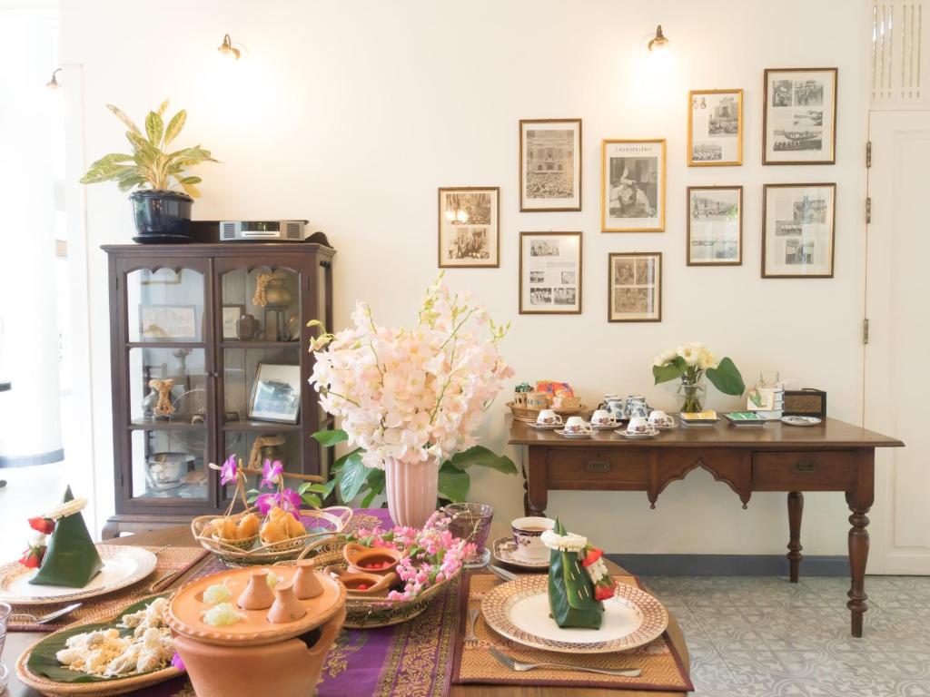 a table topped with plates and bowls of food at SSIP Boutique Dhevej Bangkok in Bangkok