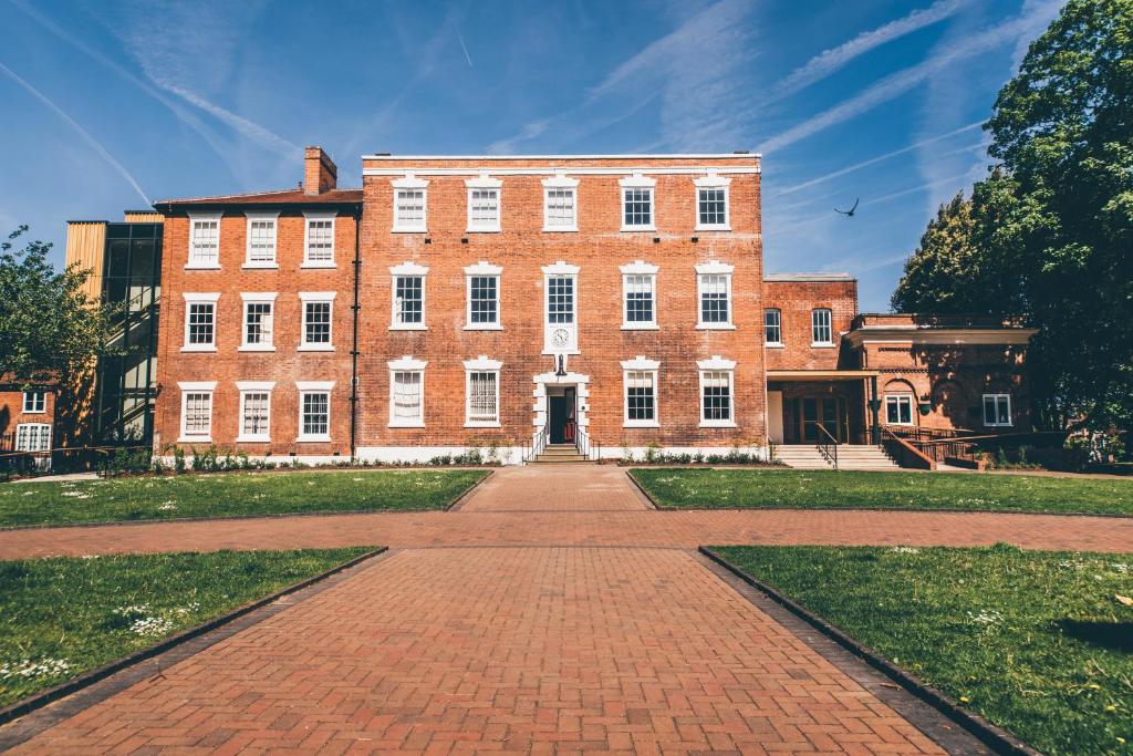 a large brick building with a brick walkway in front at Birchover Bridgford Hall in Nottingham