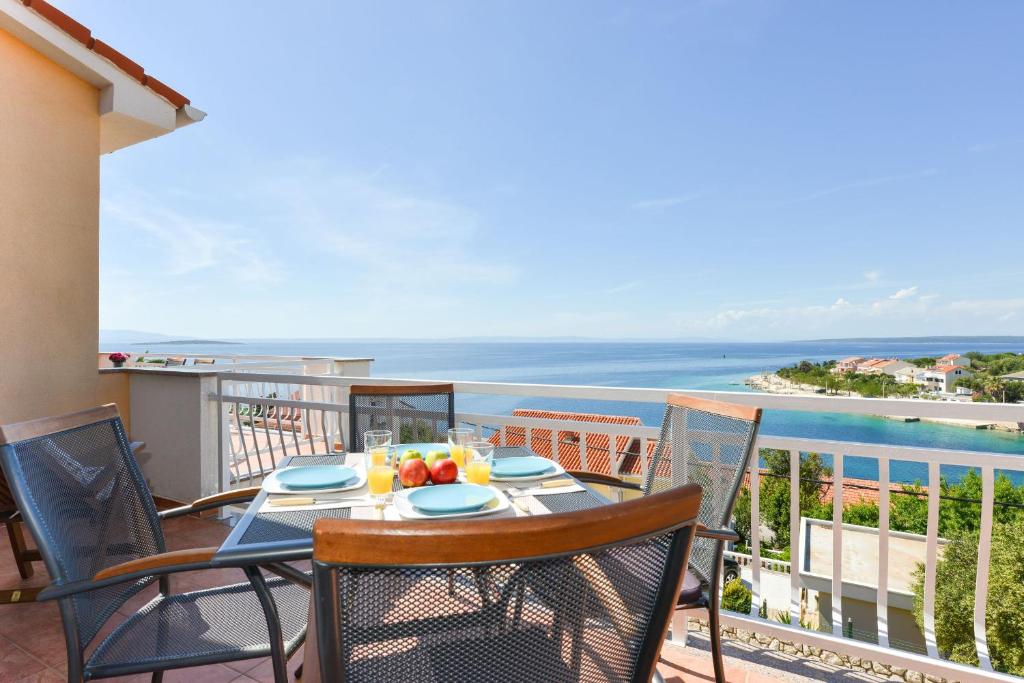 un tavolo e sedie su un balcone con vista sull'oceano di Cecilia Apartments a Lun