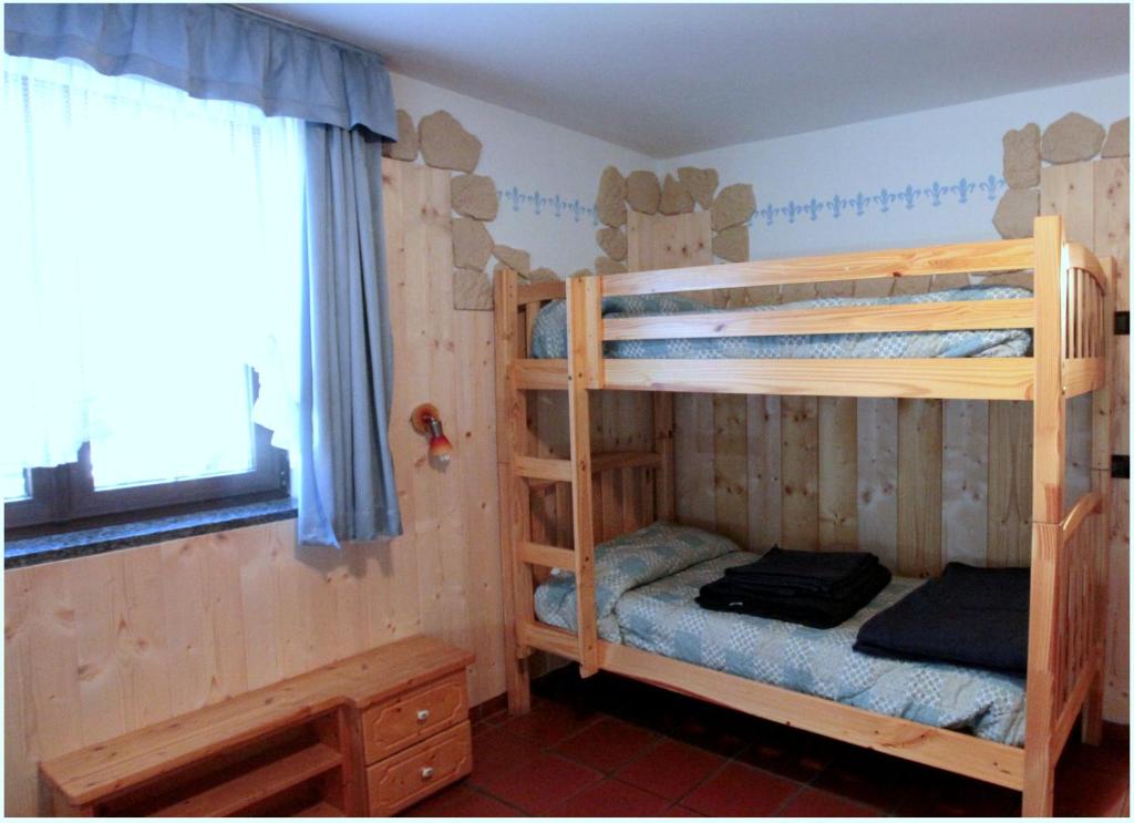 1 dormitorio con 2 literas y ventana en Maso La Vecchia Quercia, en Baselga di Pinè