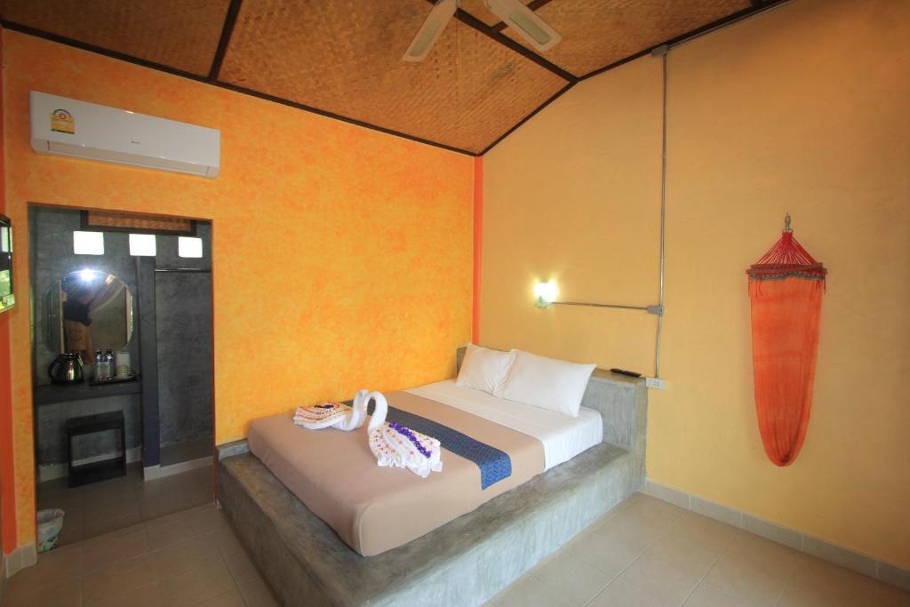 a bedroom with a bed in a room with orange walls at Beck's Resort in Haad Pleayleam