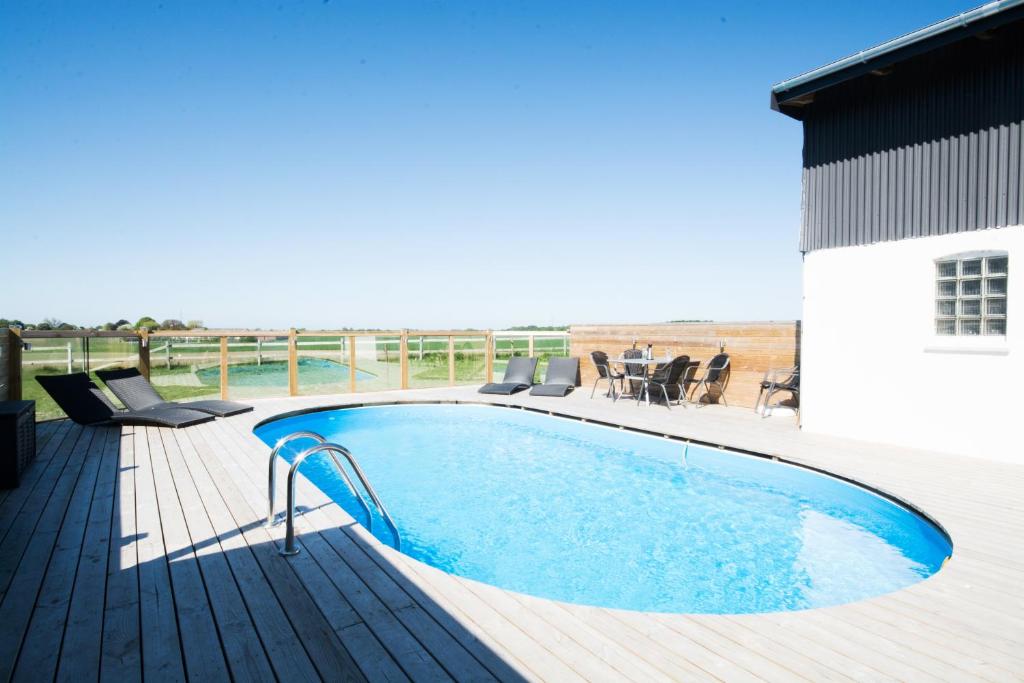 a swimming pool on a deck next to a building at Idestrup Bed and Breakfast in Idestrup