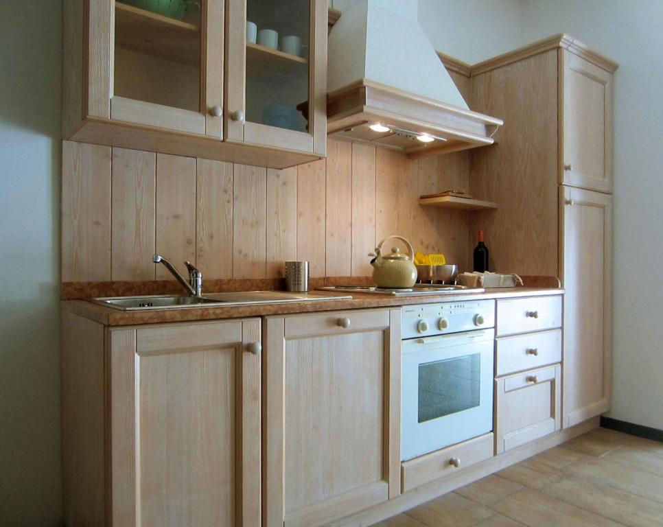 una cucina con armadi in legno, lavandino e piano cottura di casa GARDA a Garda