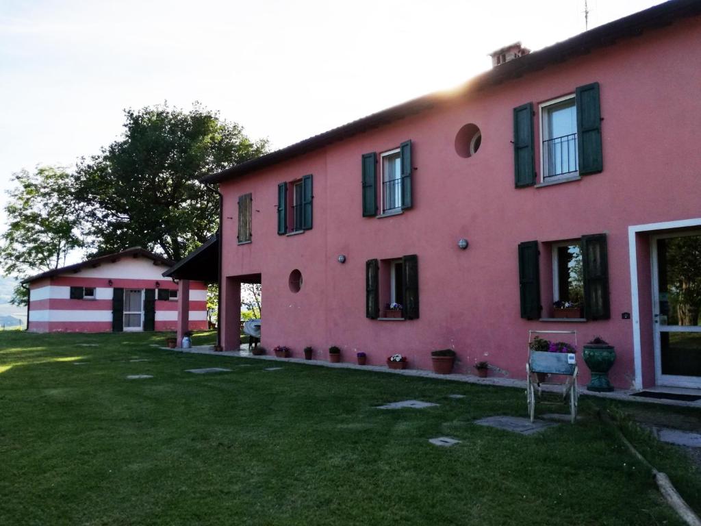 ein rosa Haus mit einem Garten davor in der Unterkunft Agriturismo Morattina in Castrocaro Terme