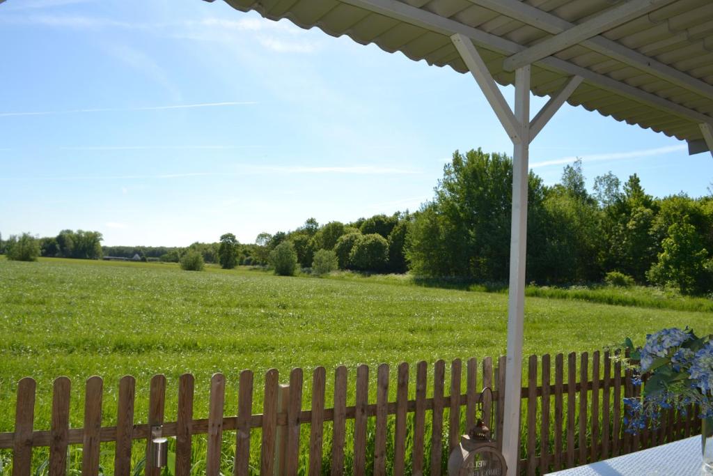 einen Zaun mit einem Feld im Hintergrund in der Unterkunft Bed & Breakfast Boszicht Leeuwarden in Leeuwarden