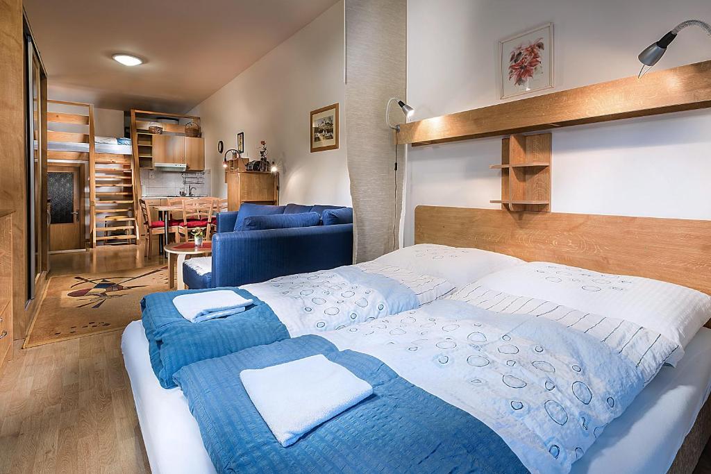 a bedroom with a large bed with blue and white sheets at Apartmánový dom Spiežovec - Ap. 4 in Donovaly