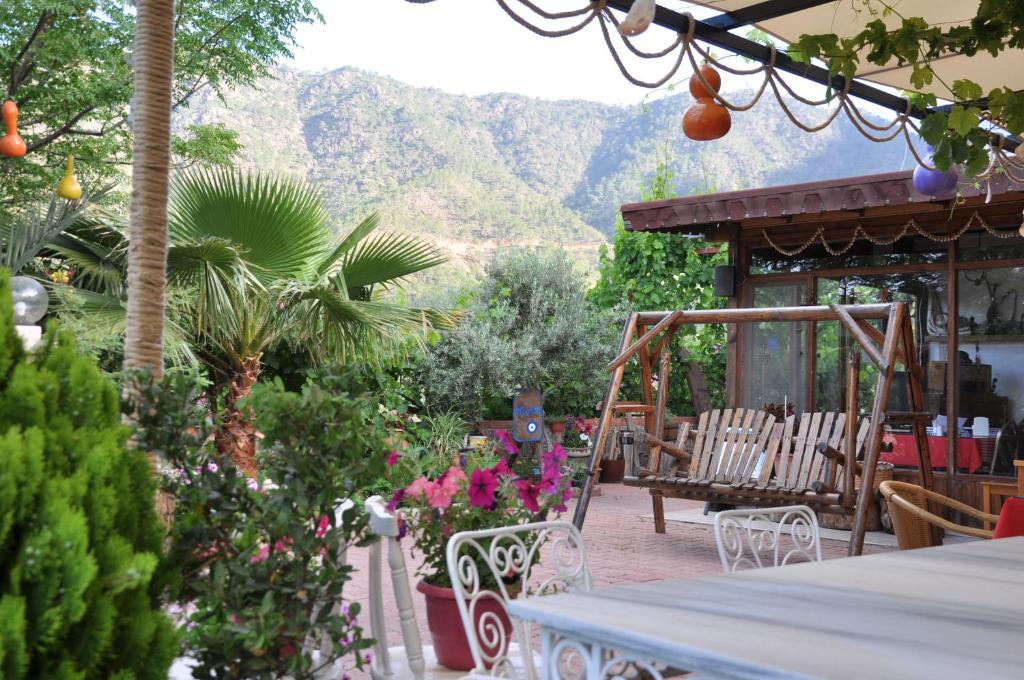 - une terrasse avec une table, des chaises et des fleurs dans l'établissement Adrasan Shambala, à Adrasan