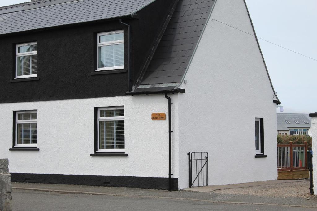 a white and black house with a black roof at Salmon House in Stornoway