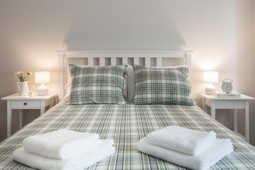um quarto com uma cama com duas toalhas brancas em Aveiro Train Flat em Aveiro