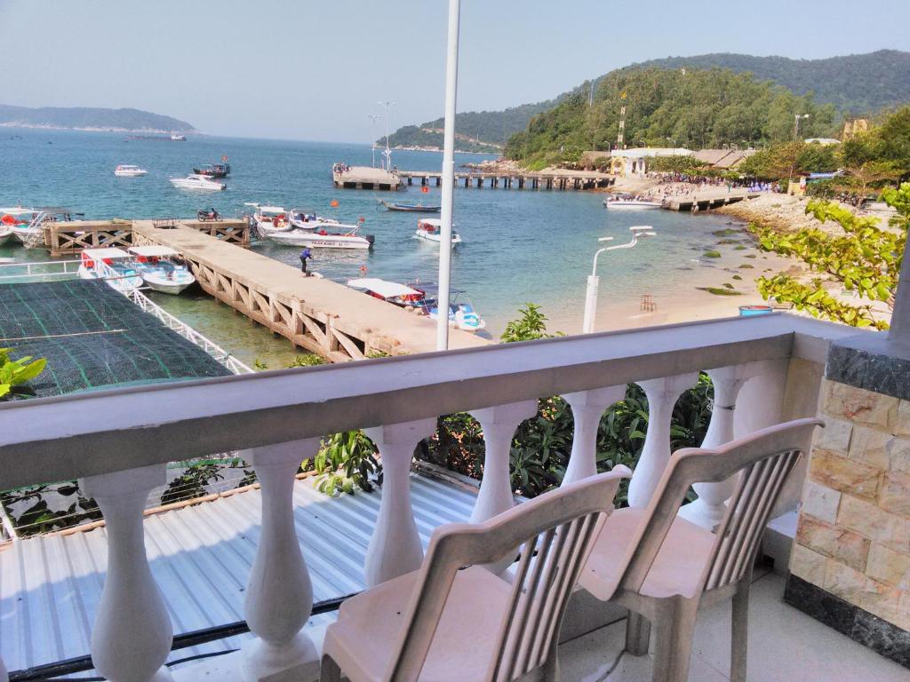 a balcony with two chairs and a view of the water at Tuan Thanh Homestay in Tân Hiệp