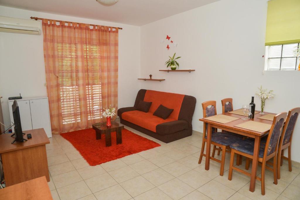salon z kanapą, stołem i krzesłem w obiekcie Latmo Apartment Zadar w mieście Zadar