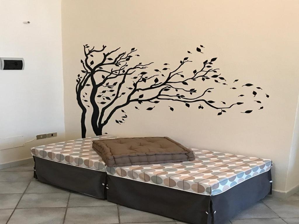 a bedroom with a bed with a tree with birds on it at MyRoom Station In Town 2 in Bergamo