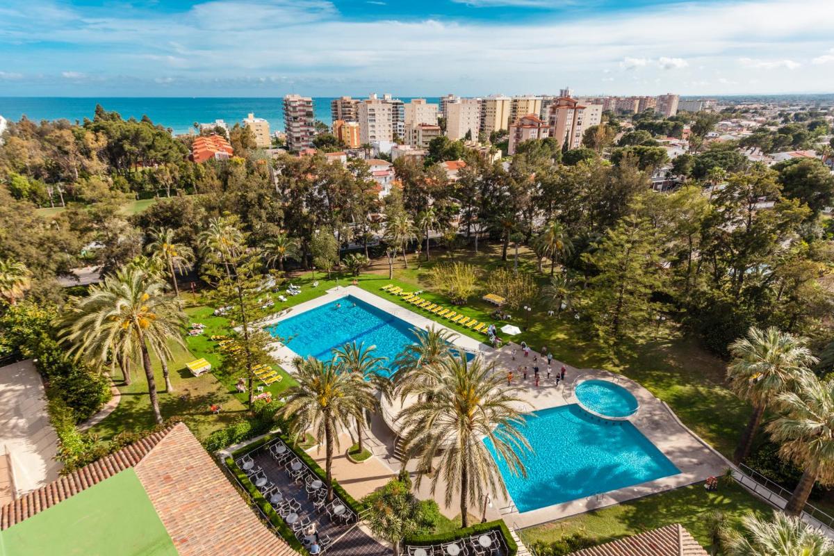 Una vista aérea de una piscina con palmeras y el océano. en Intelier Orange, en Benicàssim