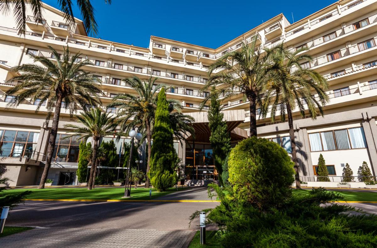Un edificio con palmeras delante. en Intelier Orange, en Benicàssim