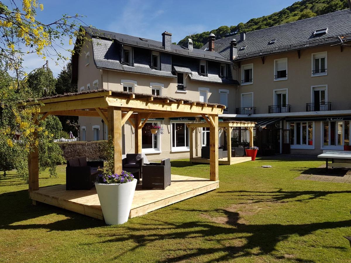 une grande maison avec un kiosque en bois dans une cour dans l'établissement Le Castelet, à Le Mont-Dore