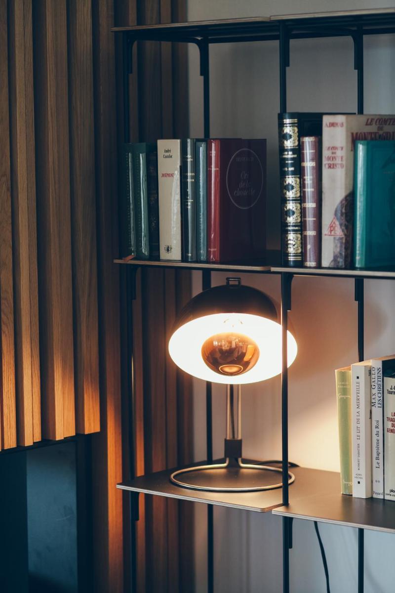 une lampe sur une étagère avec des livres dans l'établissement Hôtel & Spa Villa Seren, à Hossegor