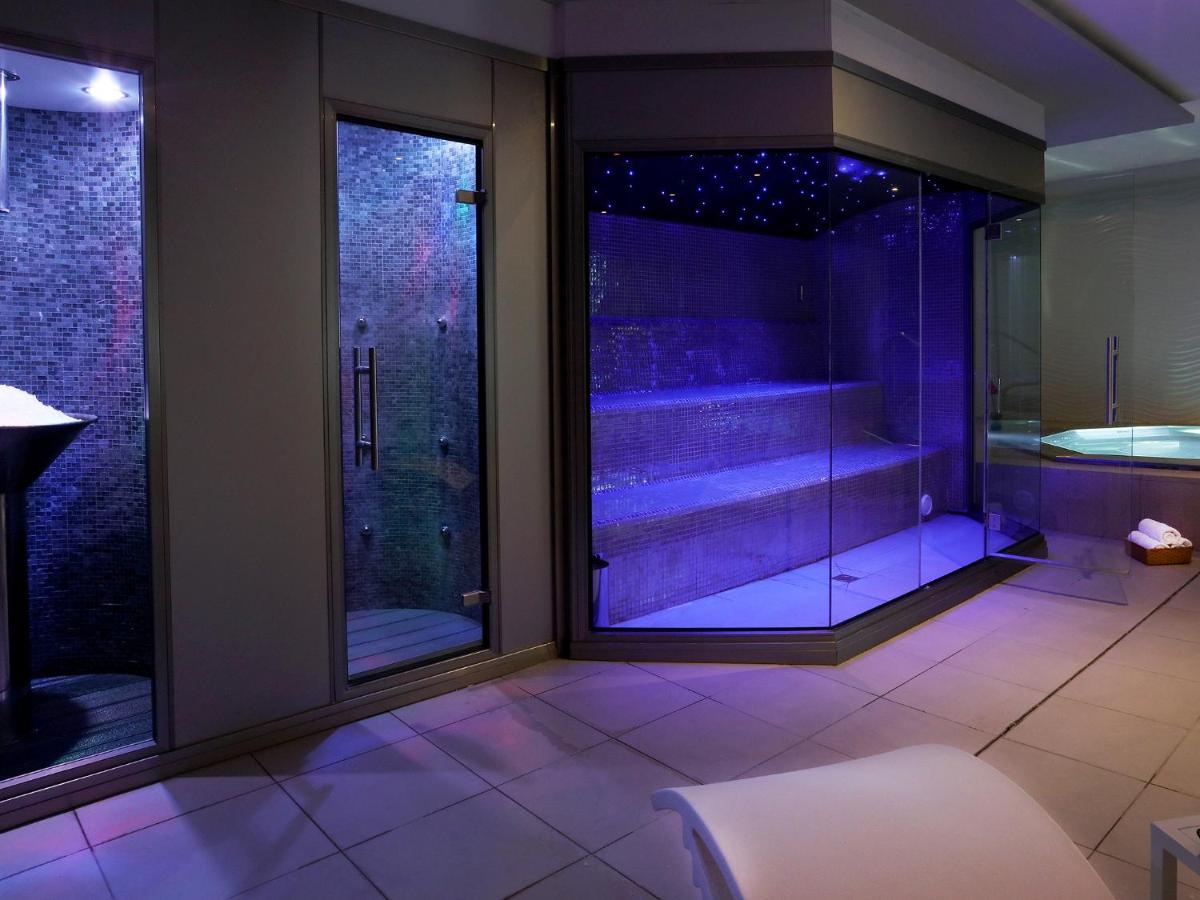 Un baño con ducha de cristal y bañera. en Axel Beach Ibiza - Adults Only, en Bahía de San Antonio