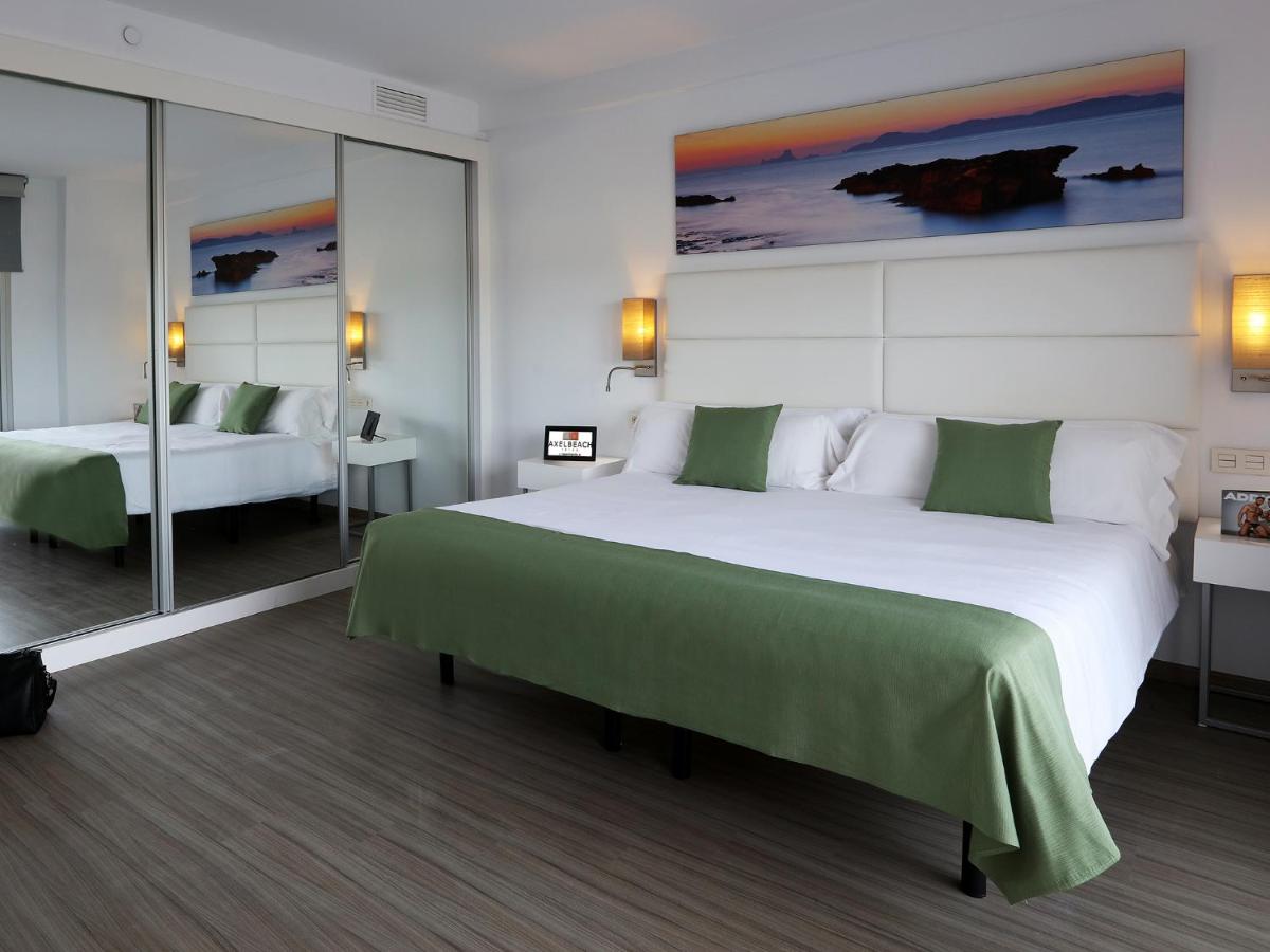 Un dormitorio con una gran cama blanca con sábanas verdes. en Axel Beach Ibiza - Adults Only, en Bahía de San Antonio 40 fotos más
