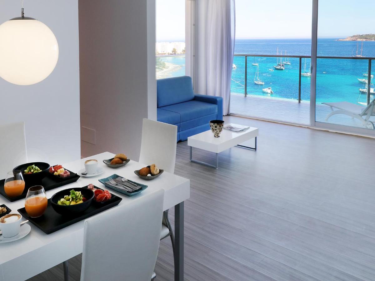 una sala de estar con una mesa con comida. en Axel Beach Ibiza - Adults Only, en Bahía de San Antonio