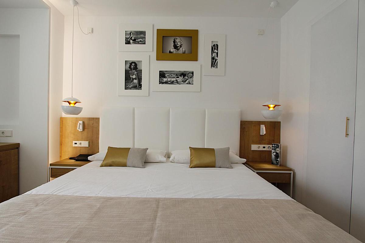 Un dormitorio con una gran cama blanca con dos mesas. en BG Rei del Mediterrani, en Playa de Muro 79 fotos más