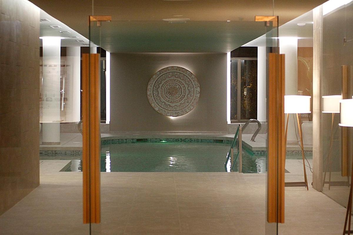 una piscina en una habitación con una casa en BG Rei del Mediterrani, en Playa de Muro