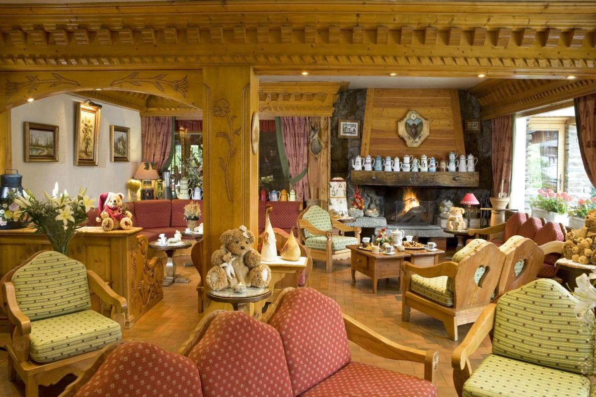 un salon meublé avec une cheminée dans l'établissement Chalet-Hôtel Neige et Roc, The Originals Relais, à Samoëns