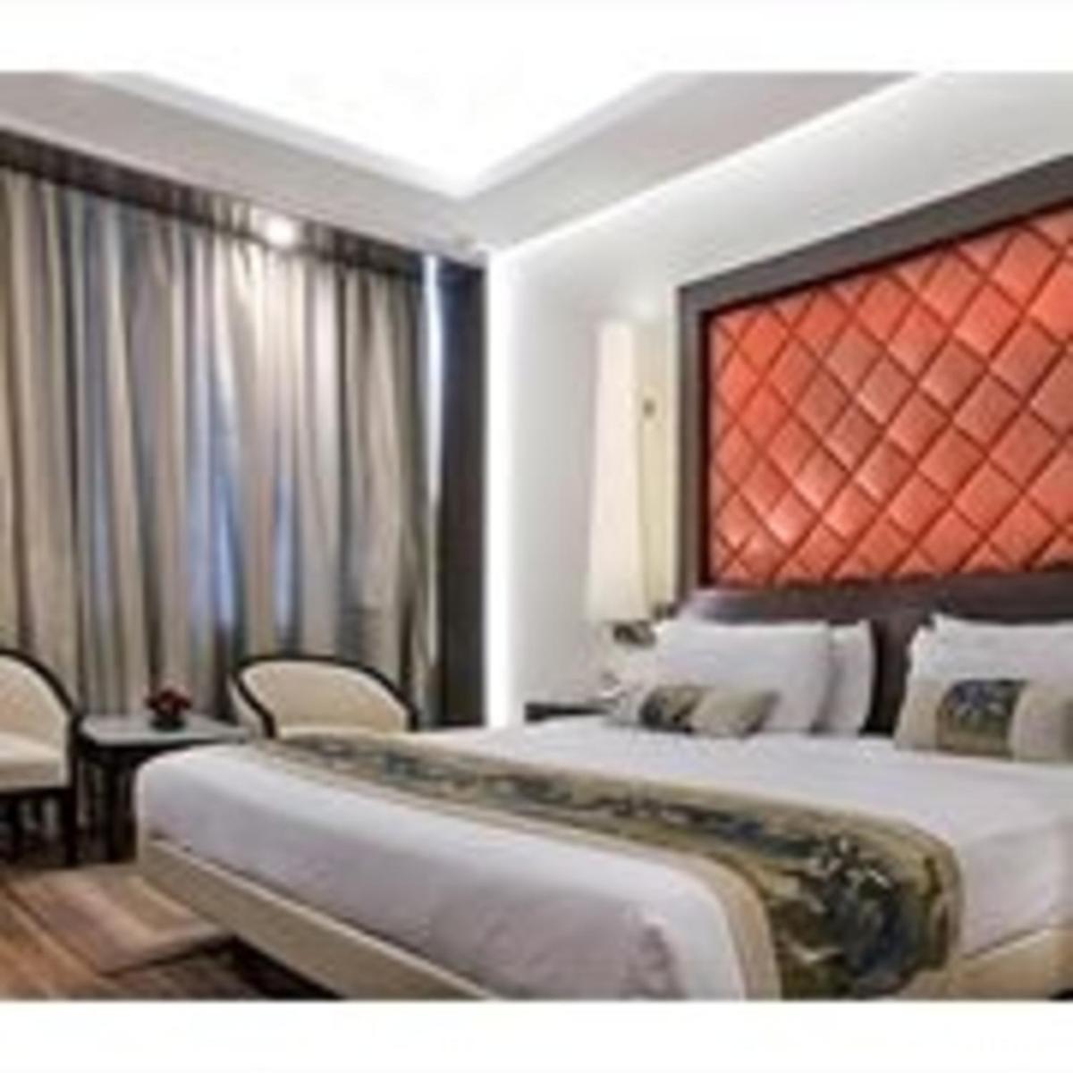 a hotel room with a bed and a large window at Clarks Avadh in Lucknow