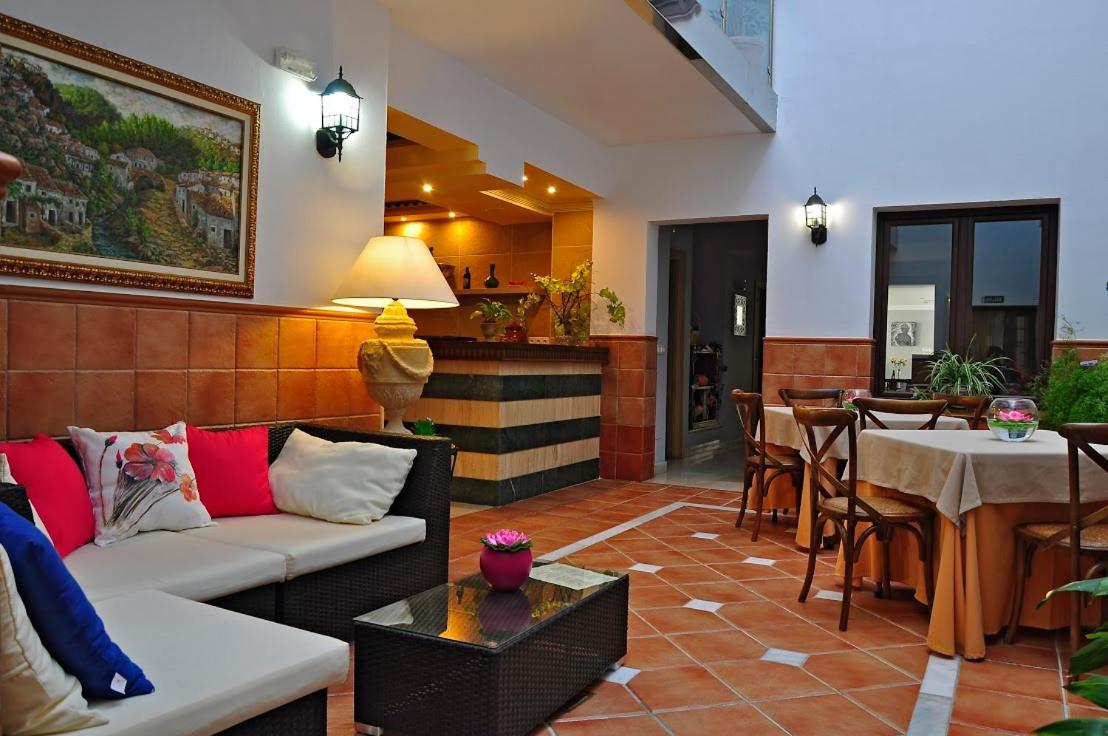 una sala de estar con un sofá y una mesa en Hotel & Spa PLAZA Arriate, en Arriate